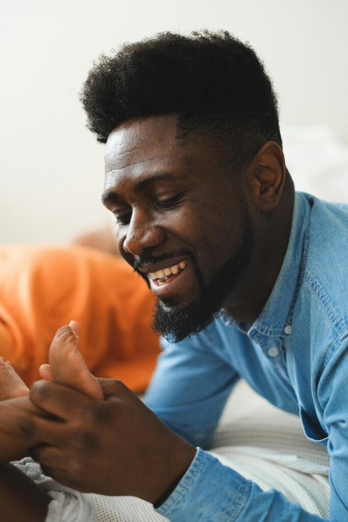 pexels-photo-11369486-11369486 A cheerful father playing with his baby, showcasing warmth and happiness indoors.